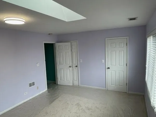 an empty room with windows and closet