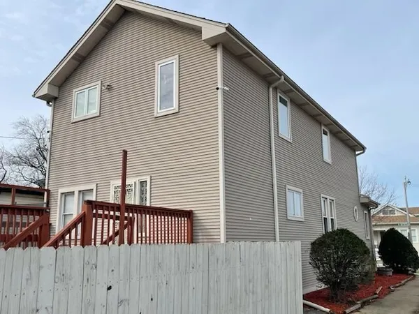 a view of a house with a wooden fence