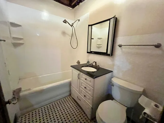 a bathroom with a granite countertop toilet sink and mirror
