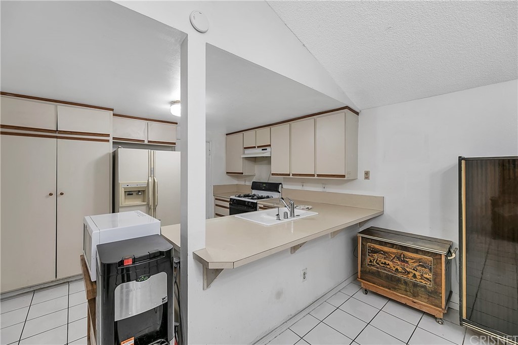 9689 Kewen Avenue Arleta, CA 91331 - Photo 9 of 28 a kitchen with a sink cabinets and refrigerator