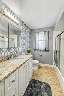 a spacious bathroom with a granite countertop sink and a mirror