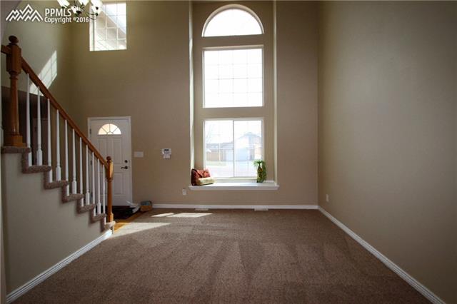 5224 Rondo Way Colorado Springs, CO 80911 - Photo 11 of 36 Elegant living room with two story windows and window seat.