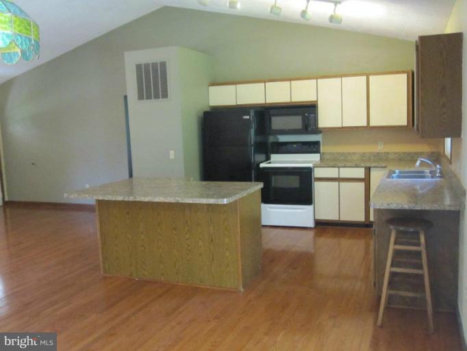 10473 Tetotum Road King George, VA 22485 - Photo 11 of 23 a kitchen with granite countertop a refrigerator and a stove top oven
