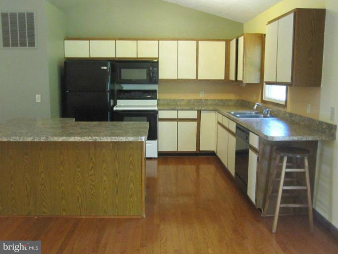 10473 Tetotum Road King George, VA 22485 - Photo 10 of 23 a kitchen with stainless steel appliances granite countertop a refrigerator a sink and a stove