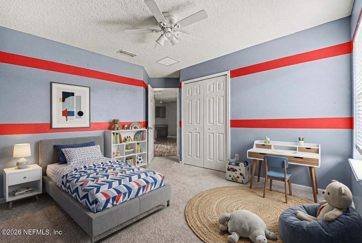 96039 Morton Lane Yulee, FL 32097 - Photo 18 of 27 a bedroom with a bed and a chandelier