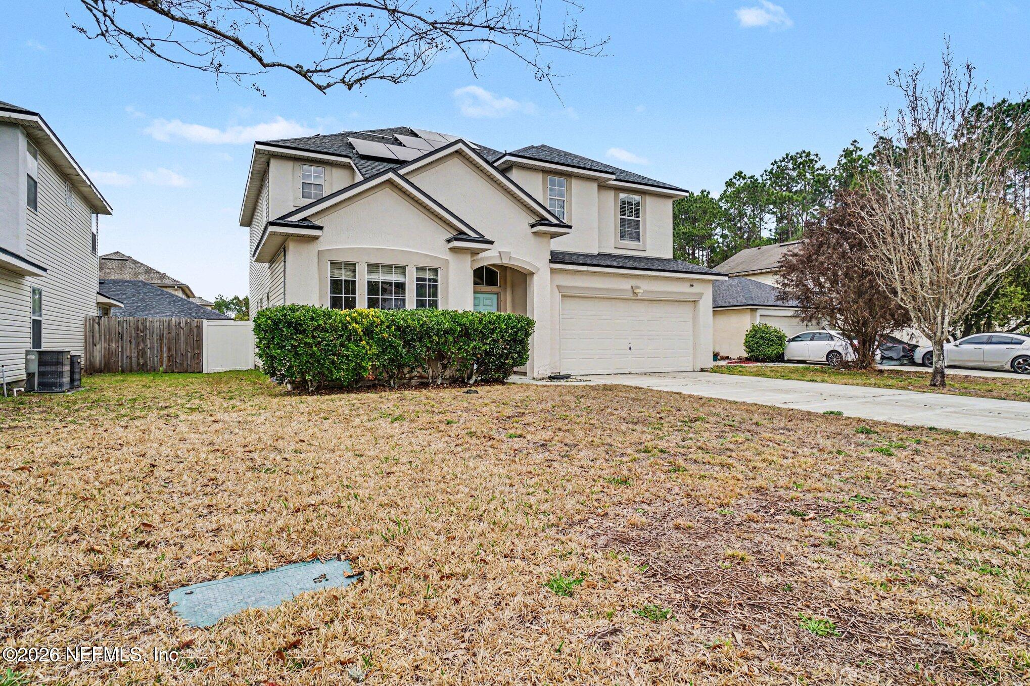 96039 Morton Lane Yulee, FL 32097 - Photo 2 of 27 a view of a white house next to a yard with a large tree