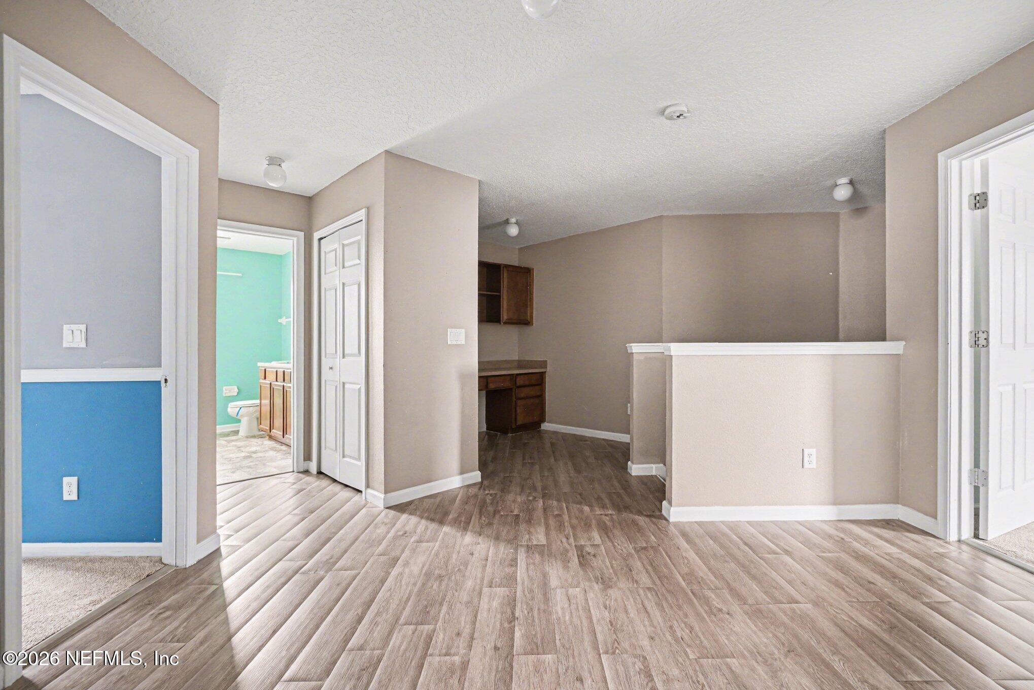 96039 Morton Lane Yulee, FL 32097 - Photo 21 of 27 a view of a hallway with wooden floor and kitchen space