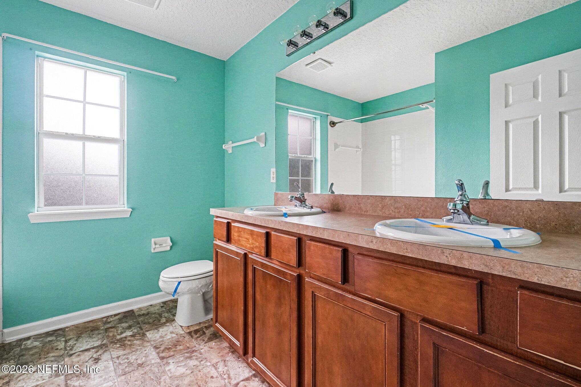 96039 Morton Lane Yulee, FL 32097 - Photo 24 of 27 a bathroom with a granite countertop toilet sink and mirror