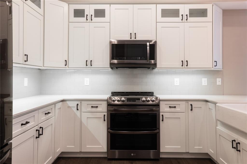 116 West Main Street, Unit 2A Blue Ridge, GA 30513 - Photo 11 of 14 a kitchen with white cabinets and stainless steel appliances
