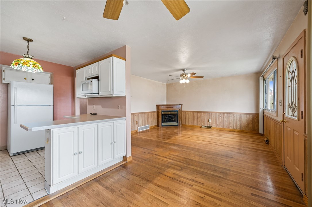 30844 Harrison Road Wickliffe, OH 44092 - Photo 6 of 30 Kitchen featuring white appliances, a wainscoted wall, light floors, and white cabinetry