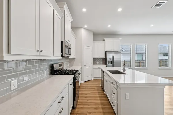 a kitchen with stainless steel appliances granite countertop a sink stove and refrigerator