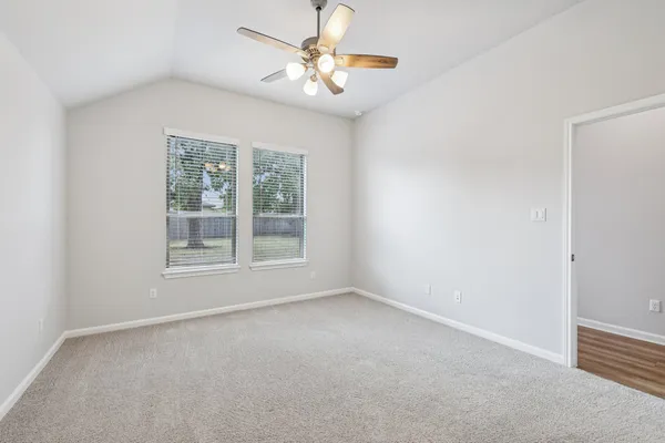 an empty room with a window and a fan