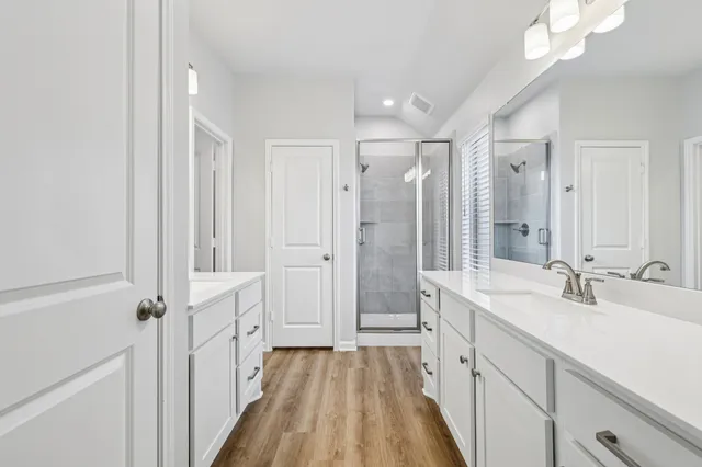 a spacious bathroom with a double vanity sink mirror and shower