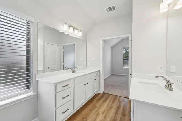 a bathroom with a double vanity sink and mirror with shower