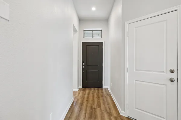 a view of a hallway view with wooden floor and closet