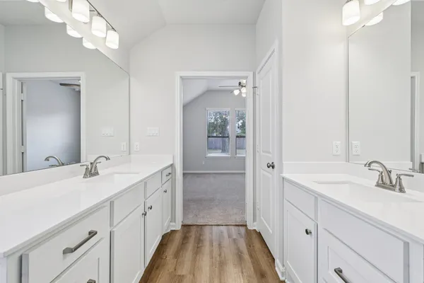 a spacious bathroom with a double vanity sink a mirror and a