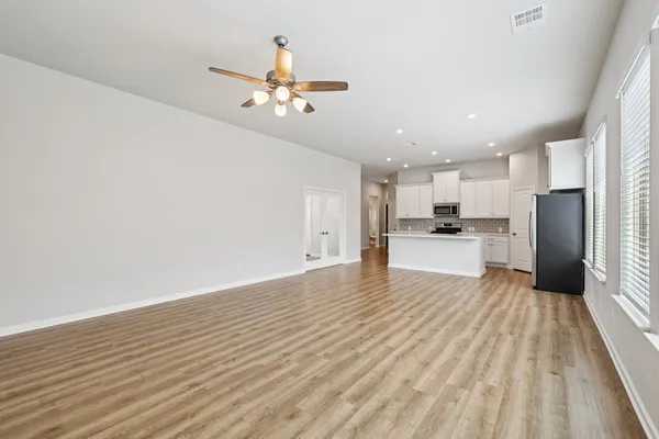 a view of kitchen with granite countertop cabinets and refrigerator