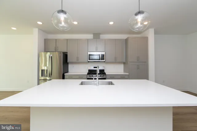 a kitchen with stainless steel appliances a refrigerator sink and microwave