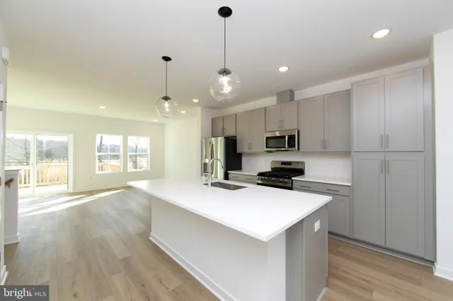 a kitchen with kitchen island a sink stainless steel appliances and cabinets