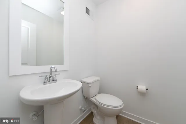 a bathroom with a sink toilet and a mirror
