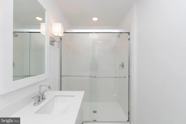 a bathroom with a shower sink and mirror