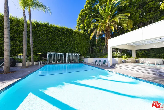 a view of a patio with table and chairs potted plants and palm trees