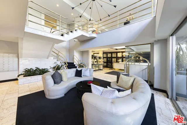 a living room with furniture a chandelier and a large window