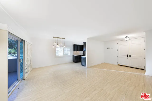 a view of a big room with windows and chandelier fan