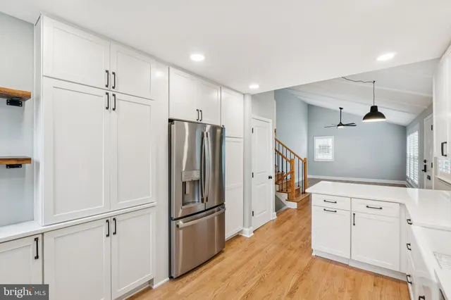 a kitchen with white cabinets and refrigerator