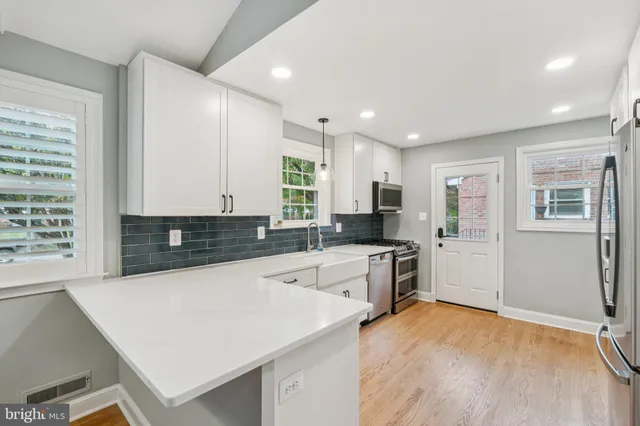 a kitchen with granite countertop a stove a sink a refrigerator and cabinets