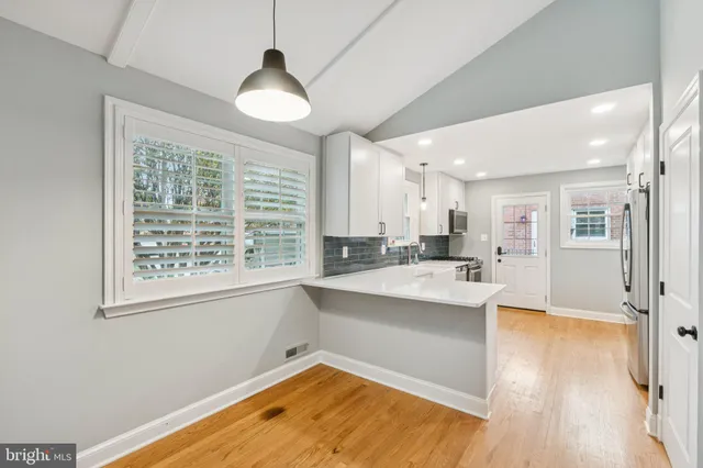 a large kitchen with a window and stainless steel appliances