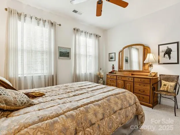 a bedroom with a bed and a dresser next to a window