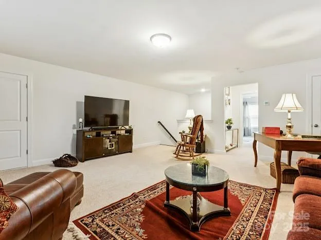 a living room with furniture a flat screen tv and a table