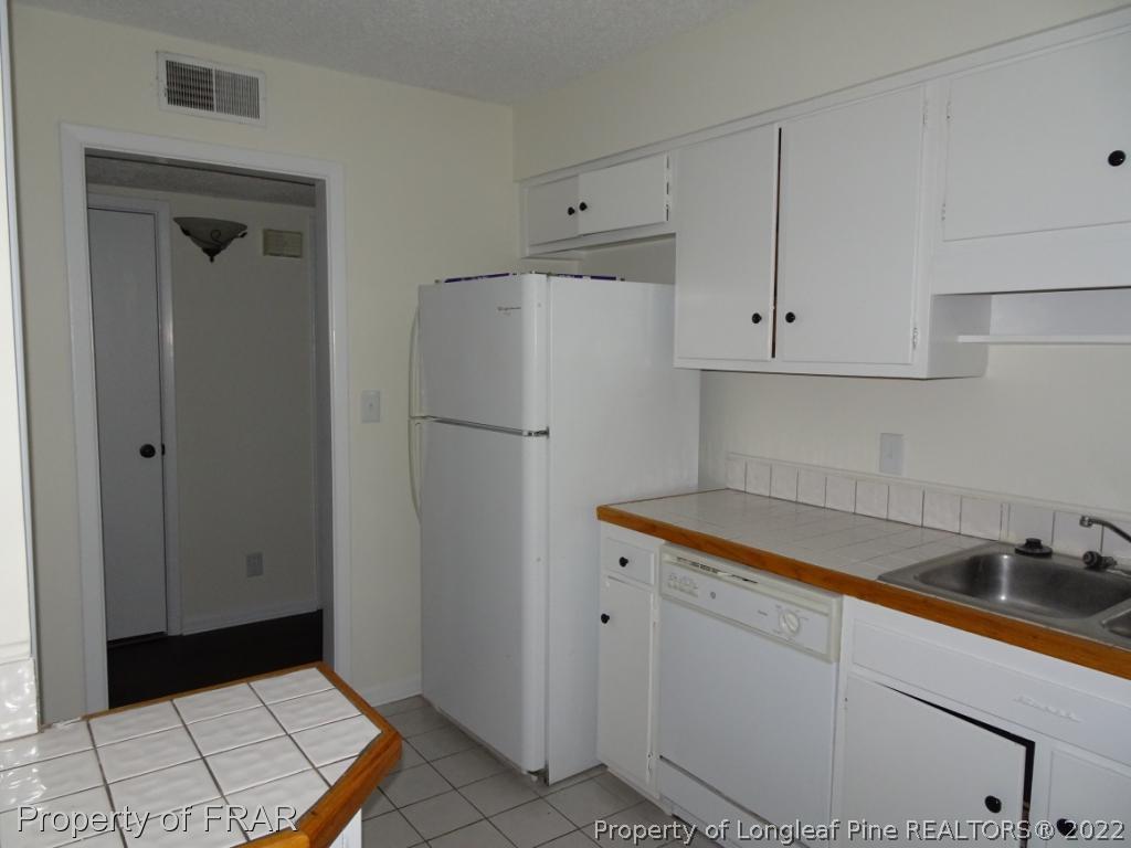 571 F Winding Creek Road Fayetteville, NC 28305 - Photo 4 of 15 a kitchen with a refrigerator and cabinets