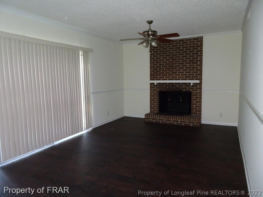 571 F Winding Creek Road Fayetteville, NC 28305 - Photo 6 of 15 a view of an empty room with wooden floor and a fireplace
