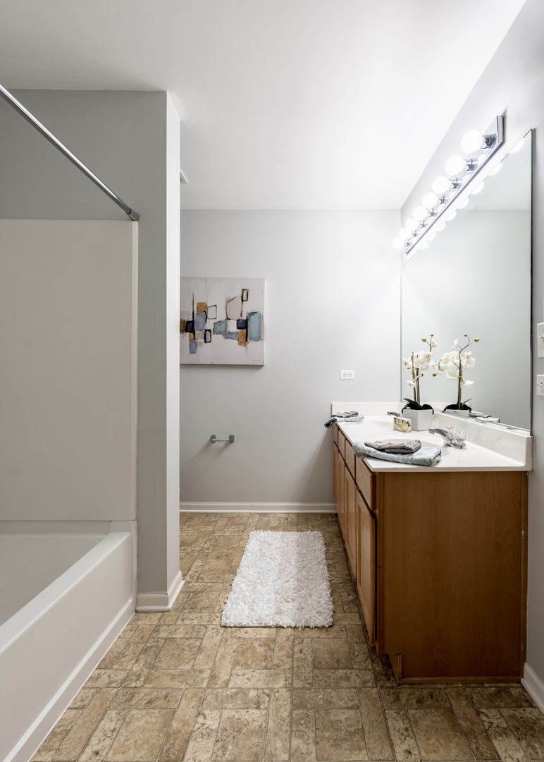 159 Springbrook Trail South Oswego, IL 60543 - Photo 26 of 32 a bathroom with a sink a mirror and a bathtub
