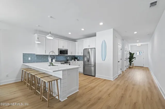 a bedroom with a bed a couch and a potted plant on the dresser