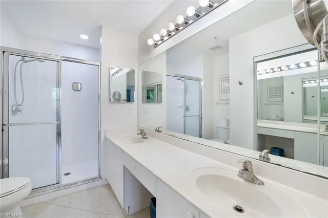 a bathroom with a double vanity sink mirror and toilet
