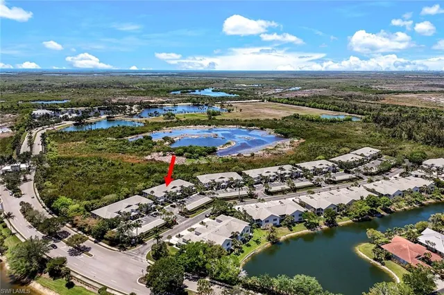 an aerial view of ocean and residential houses with outdoor space