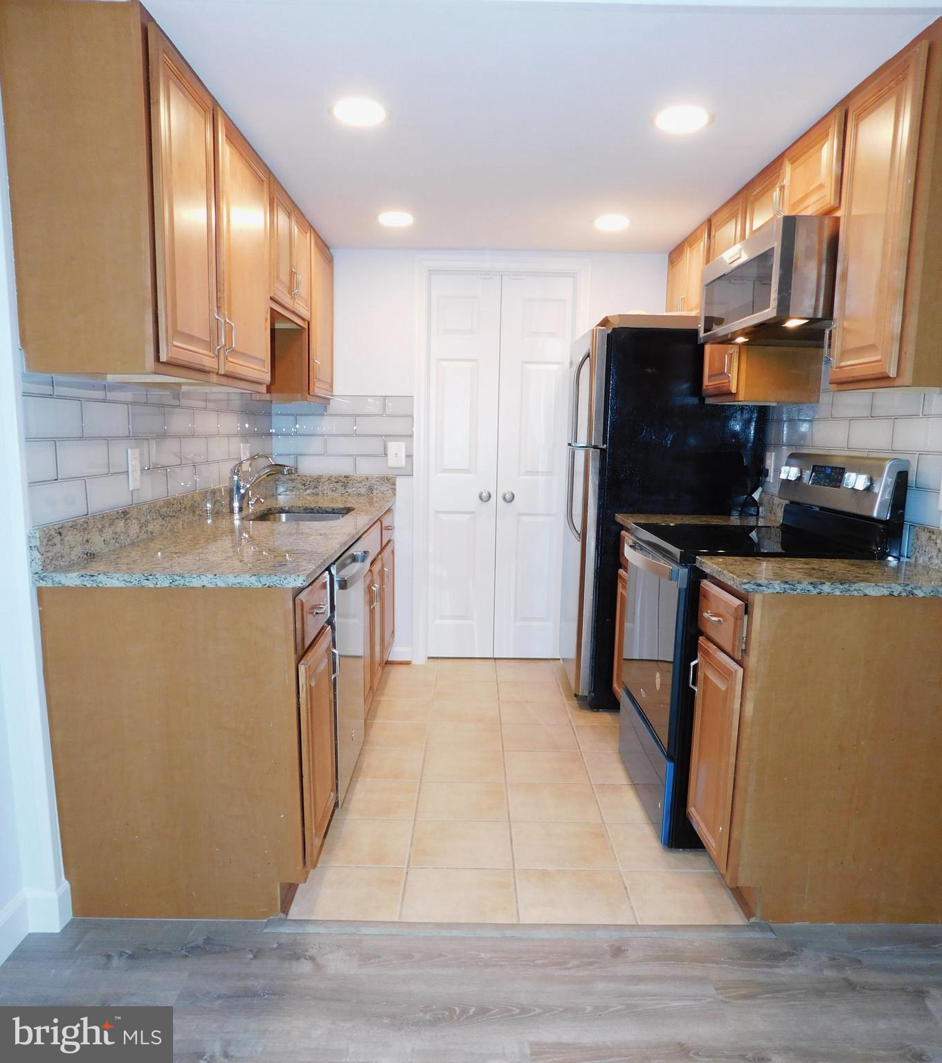 11601 Stoneview Square, Unit 11C Reston, VA 20191 - Photo 6 of 37 Galley kitchen: maple cabs, LED lites and granite
