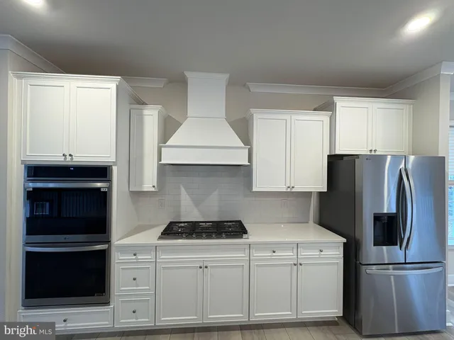 a kitchen with a refrigerator and a stove top oven