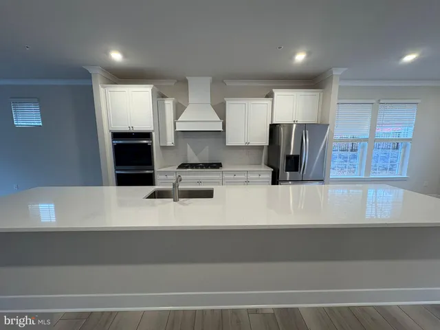 a kitchen with kitchen island a counter top a stove and a refrigerator