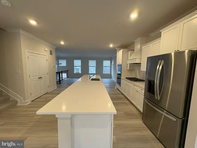 a kitchen with stainless steel appliances a refrigerator and a stove top oven