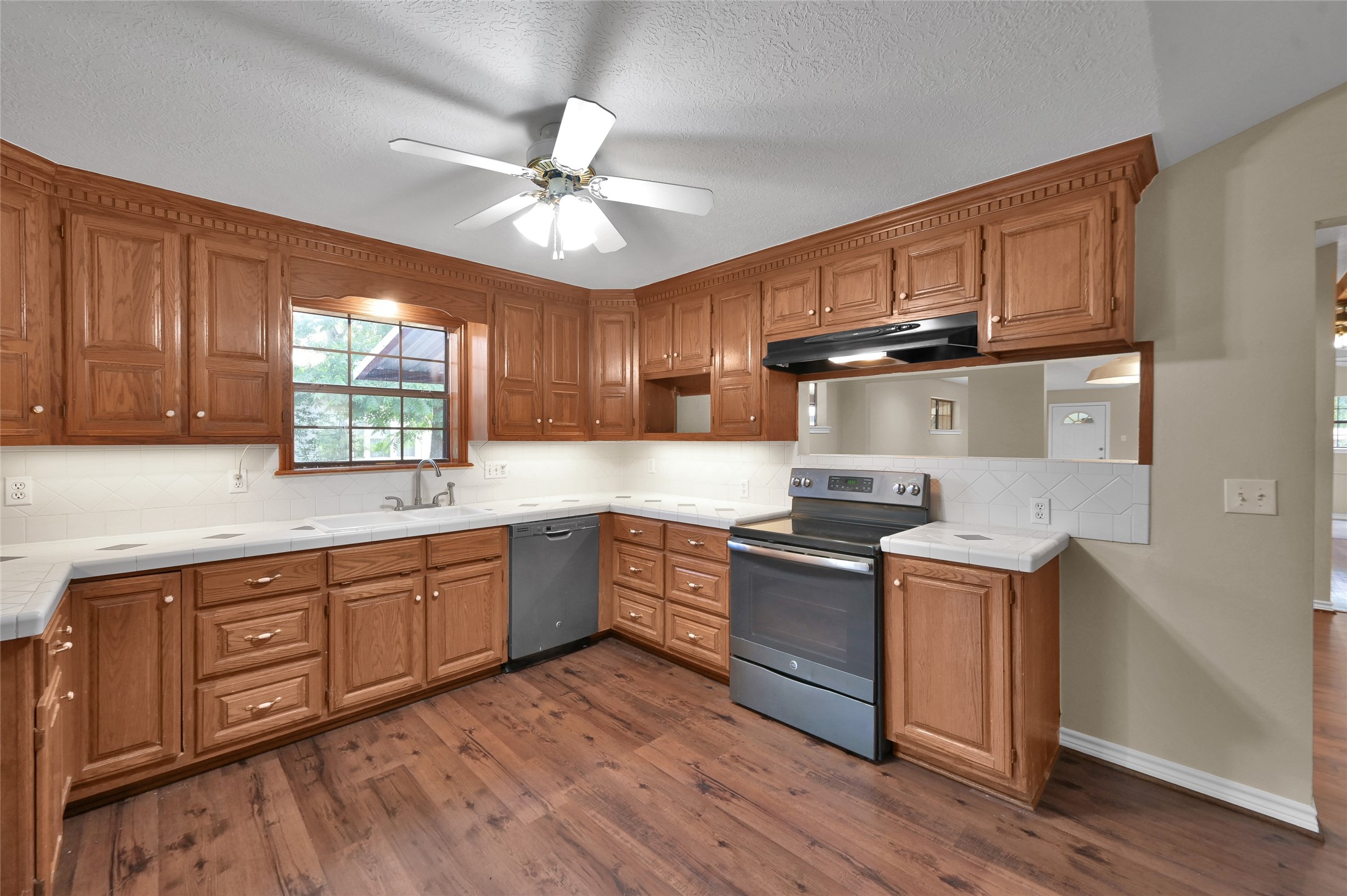 511 East Front Street New Waverly, TX 77358 - Photo 11 of 38 a kitchen with stainless steel appliances granite countertop wooden cabinets and a stove top oven