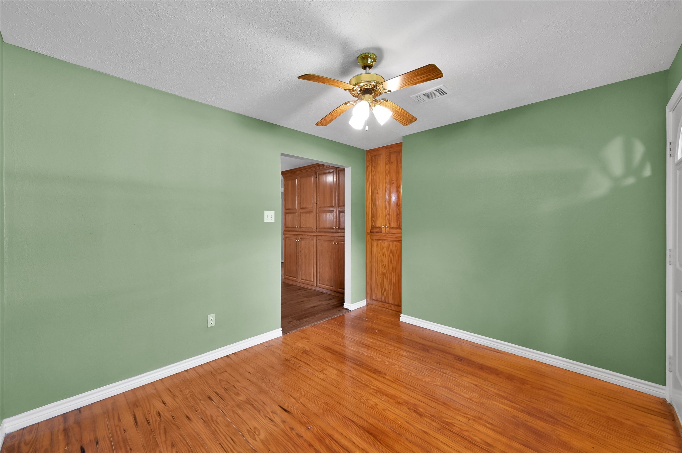 511 East Front Street New Waverly, TX 77358 - Photo 20 of 38 a view of an empty room with wooden floor and a ceiling fan