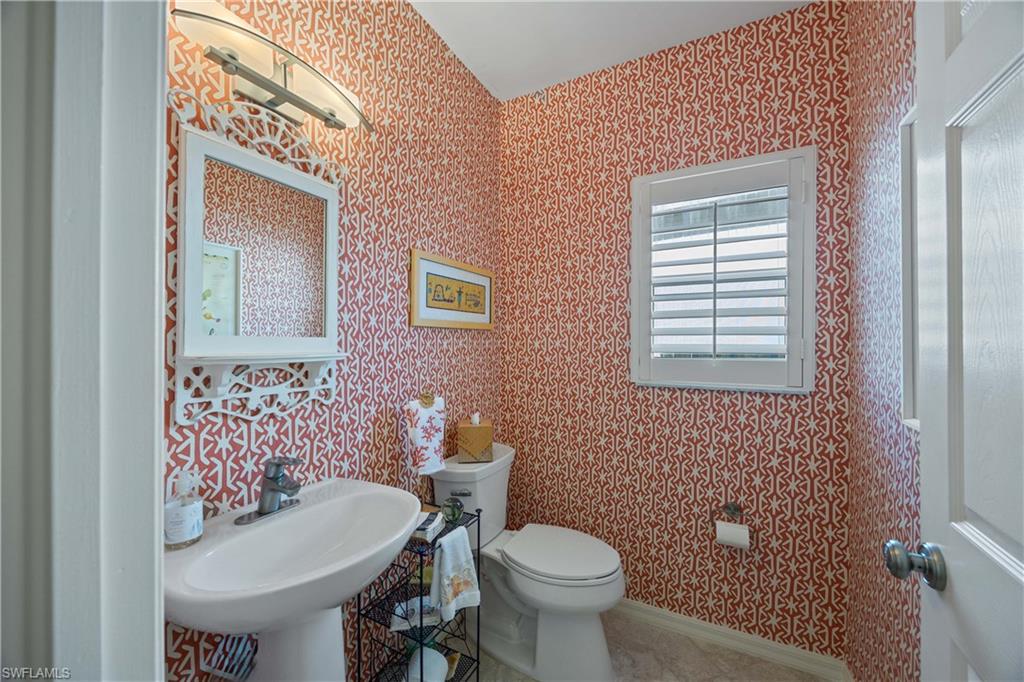 1936 Timarron Way Naples, FL 34109 - Photo 24 of 49 a bathroom with a toilet a sink and mirror