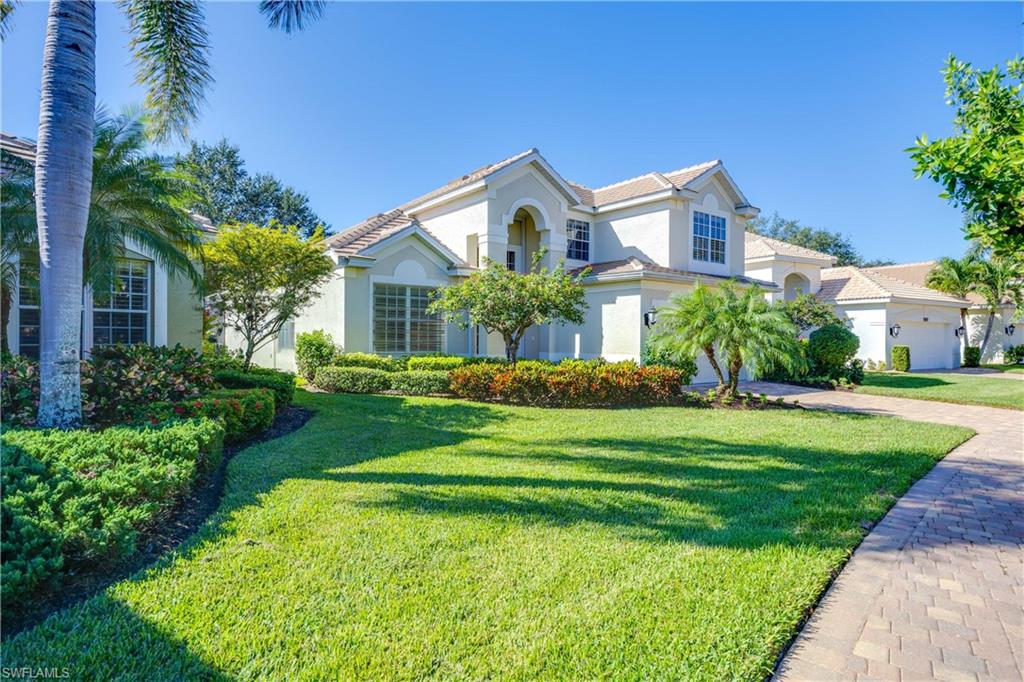 1936 Timarron Way Naples, FL 34109 - Photo 3 of 49 a front view of a house with a yard and potted plants