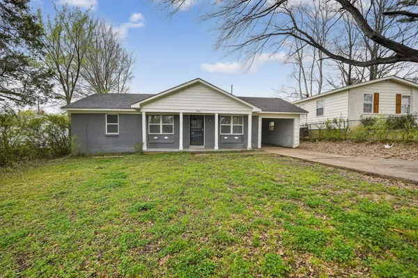a front view of a house with a garden and yard