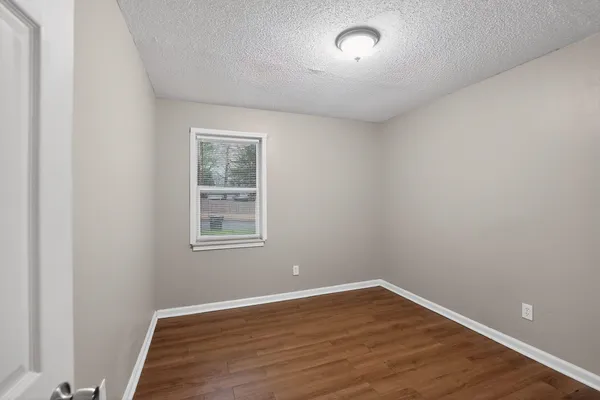 a kitchen with a refrigerator and white cabinets