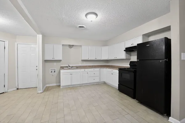 a large white kitchen with cabinets